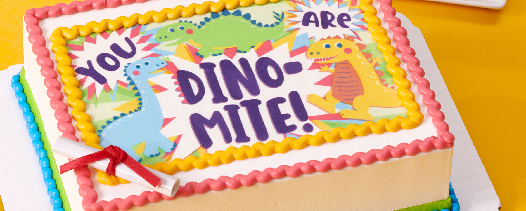 Edible cake topper with dino-mite graduation dinosaur design